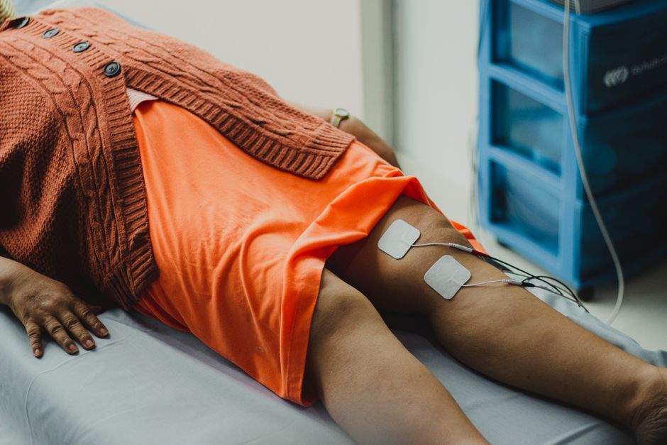 Electrotherapy pads placed on a patient's leg during a treatment session